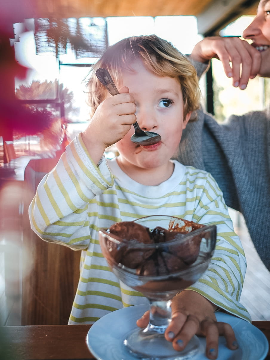 Niño disfrutando un postre en el restaurante